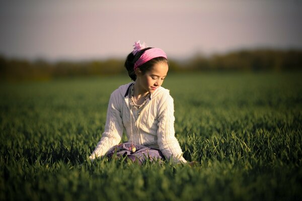 Fille sur un champ vert. C est le printemps