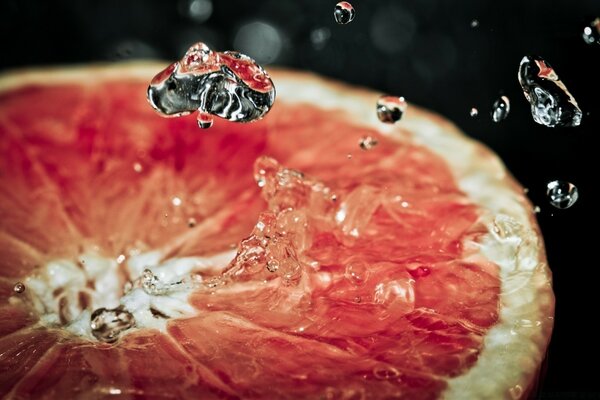 Fotografía macro de gotas abrasadoras en una fruta cortada