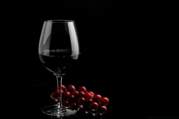 Un puñado de cerezas jugosas a una gran Copa de vino