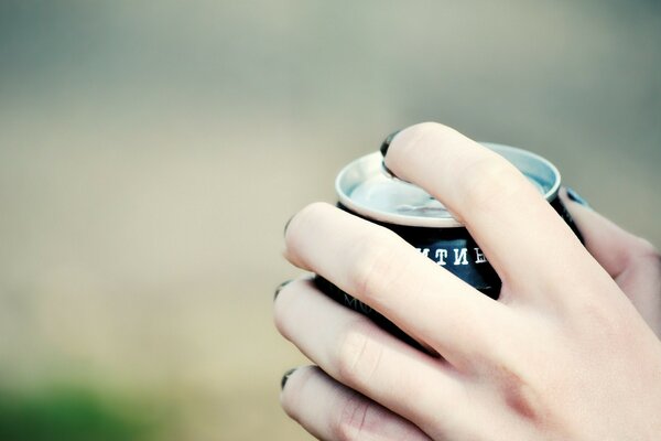 A woman s hand tearing off a jar of drink