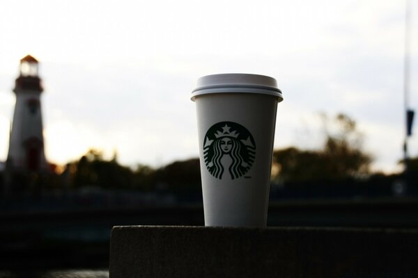 A Starbucks cup on a city background