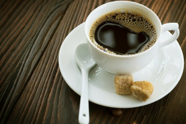 Schwarzer Kaffee in einer weißen Tasse und Zucker