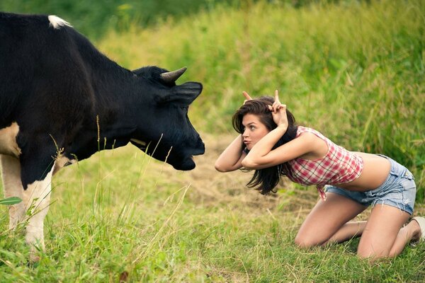 Chica retorciéndose las caras de una vaca