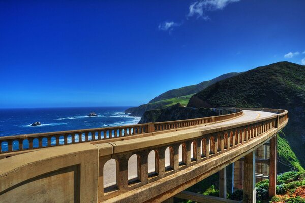 Ponte sull oceano blu che conduce alle colline