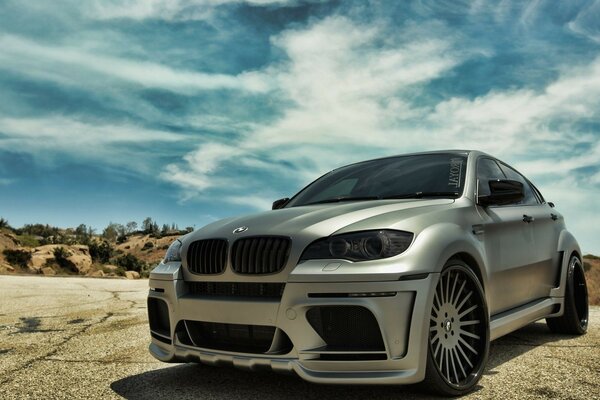 Grey BMW car in a mountainous area under a blue sky