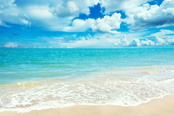 Blaues Meer,, gelber Sand, weiße Wolken