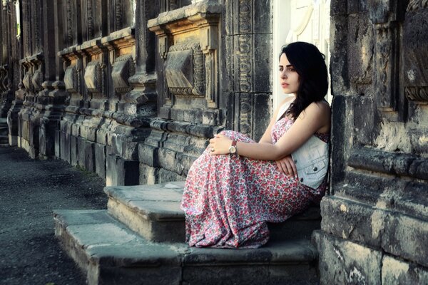 A lonely girl is sitting on the street