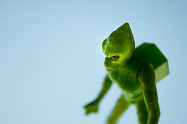 Grüner Alien mit einer Last auf dem Rücken