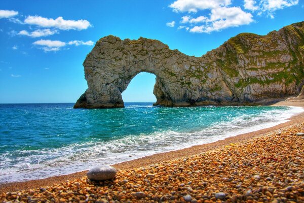 Seashore with rocks under a blue sky