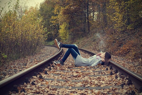 Ragazza che fuma sui binari del treno