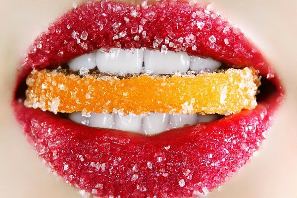 Les lèvres féminines tiennent une tranche de fruit sucré
