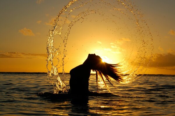 Chica en el mar al atardecer