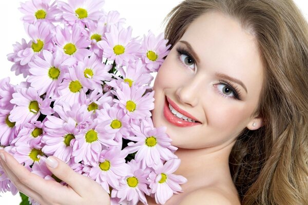 Schöne Frau mit einem Blumenstrauß aus Gänseblümchen