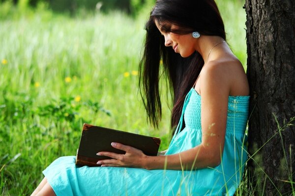 La ragazza con il libro dell aria dell albero si siede