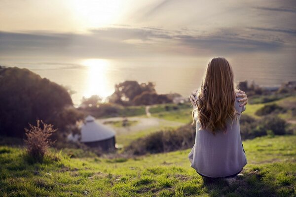 Fille au coucher du soleil dans le champ sur l herbe