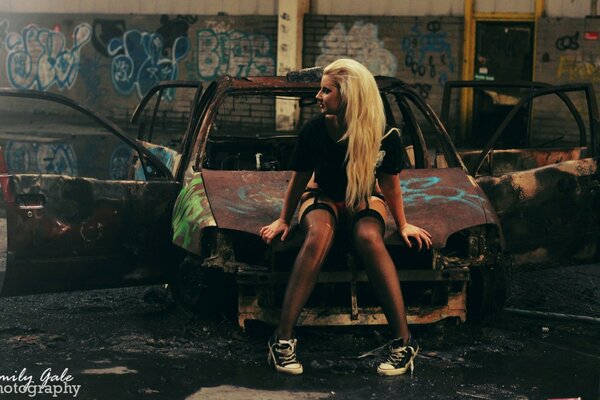 A girl in a car in stockings and sneakers