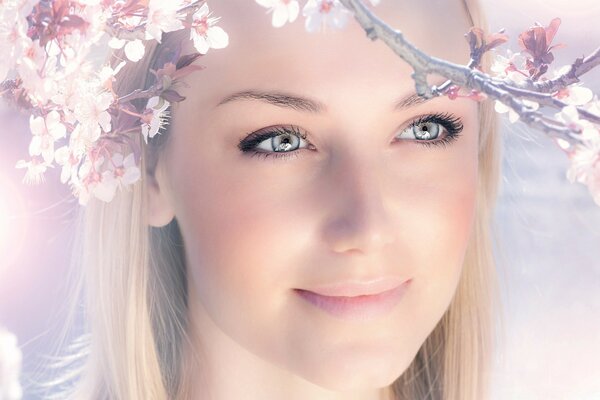 A smiling girl and a branch of a tree with flowers