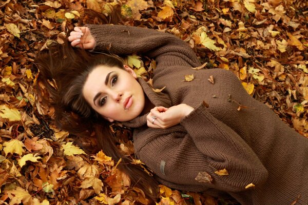 Beautiful girl on a background of yellow leaves