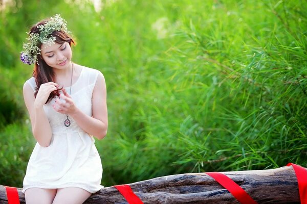 Beautiful girl with a wreath on her head in nature