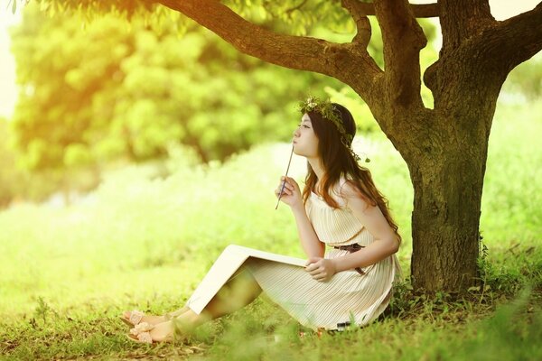 Fille dans le jardin sous un arbre écrit un mémoire