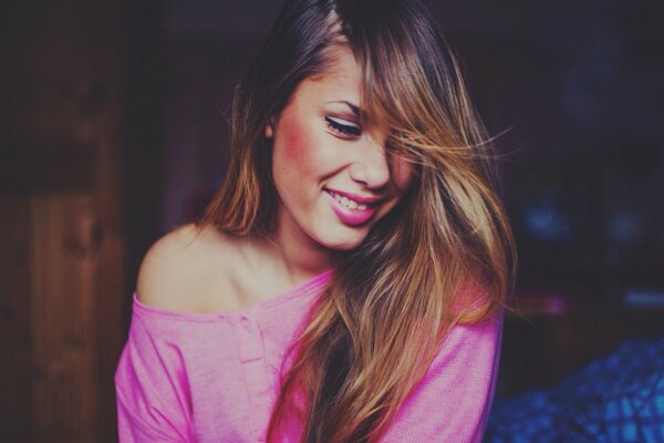 A girl with long hair in a pink blouse