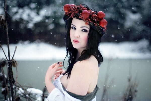 Красивая девушка с красным венком на голове зимой