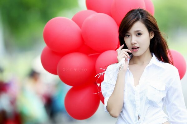 Chica en blanco con bolas rojas