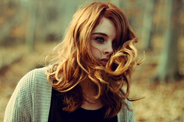 Red-haired girl in the autumn forest