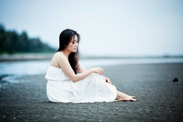 Fille en robe blanche sur la plage