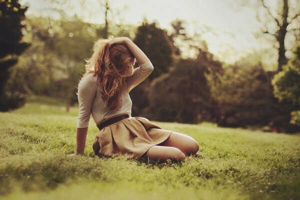 Chica sentada en la hierba en la naturaleza