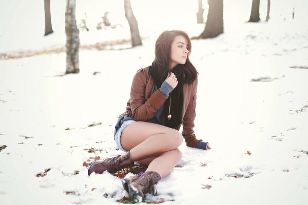 सर्दियों की शुरुआत में बर्फ में एक लड़की