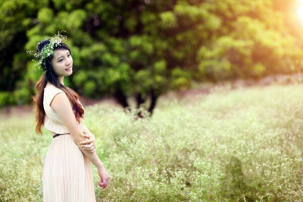 Menina com uma grinalda na natureza