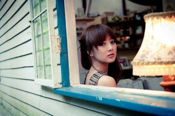 Chica joven mirando por la ventana