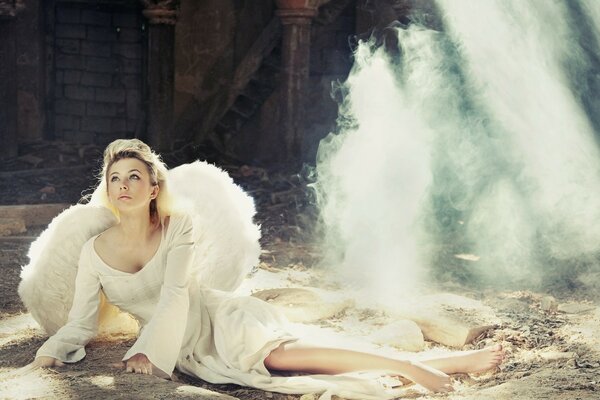 Chica con vestido blanco con alas blancas en el Suelo