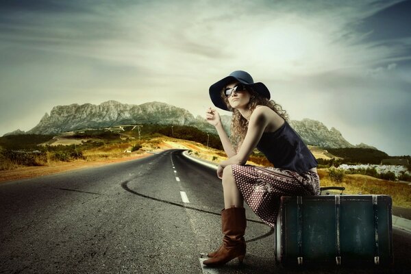 Auto-stop. Fille au chapeau sur la route