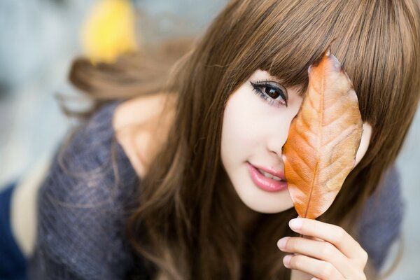 Mädchen mit langen Haaren mit einem Blatt in der Hand