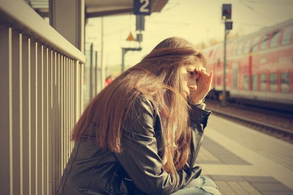 Das Mädchen auf der Plattform wartet auf den Zug. Lange Haare