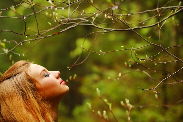 Fille reniflant les bourgeons des arbres