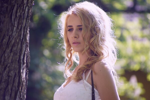 Blonde girl in a white top in nature