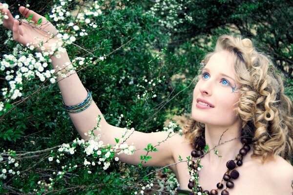 A girl with a necklace around her neck in a summer garden