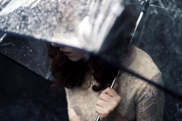 A lonely girl under a transparent umbrella