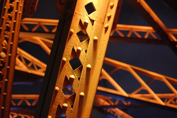 Bridge supports illuminated by lanterns. On a dark night