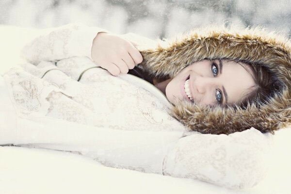 The girl is lying on the snow