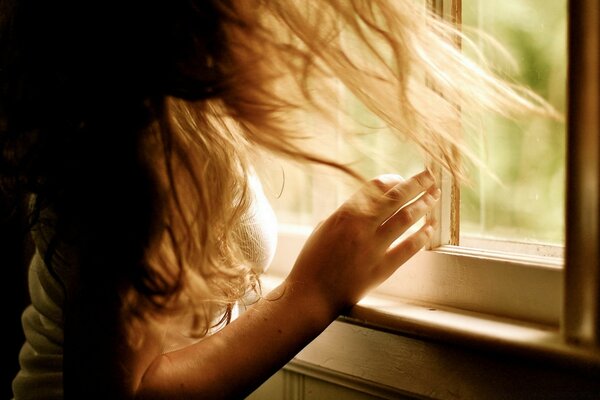 Chica joven en el fondo de una ventana abierta