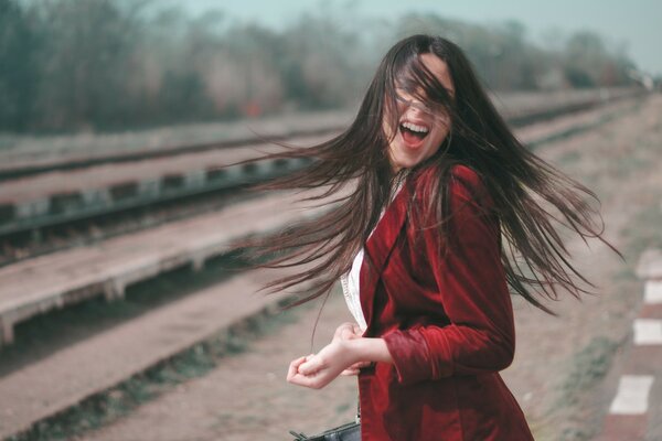 The girl in front of the rails leading into the distance