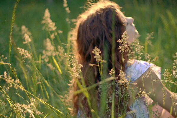 A girl with her eyes closed in a field