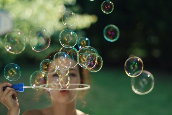 The girl blows soap bubbles