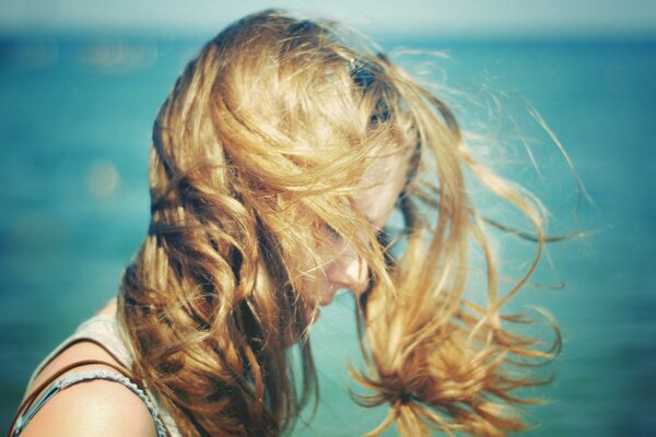 The wind blows the hair on the seashore