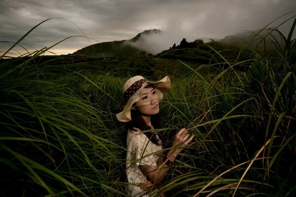 Chica con sombrero en un campo de niebla