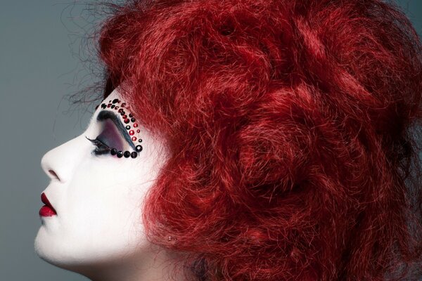 Red-haired girl with rhinestones over her eyebrows